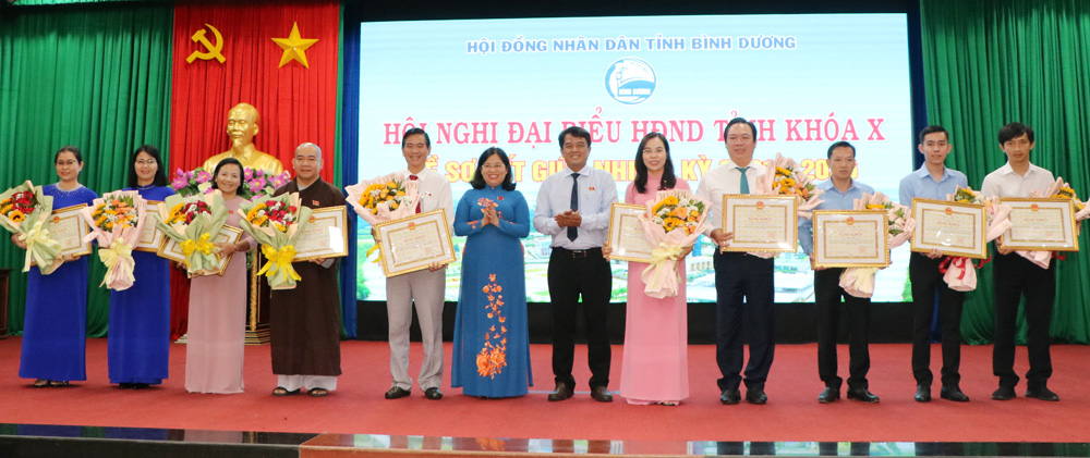 Đồng chí Bùi Thanh Nhân, Ủy viên Thường vụ, Trưởng ban Dân vận Tỉnh ủy và đồng chí Nguyễn Trường Nhật Phượng trao tặng bằng khen và hoa cho các cá nhân.